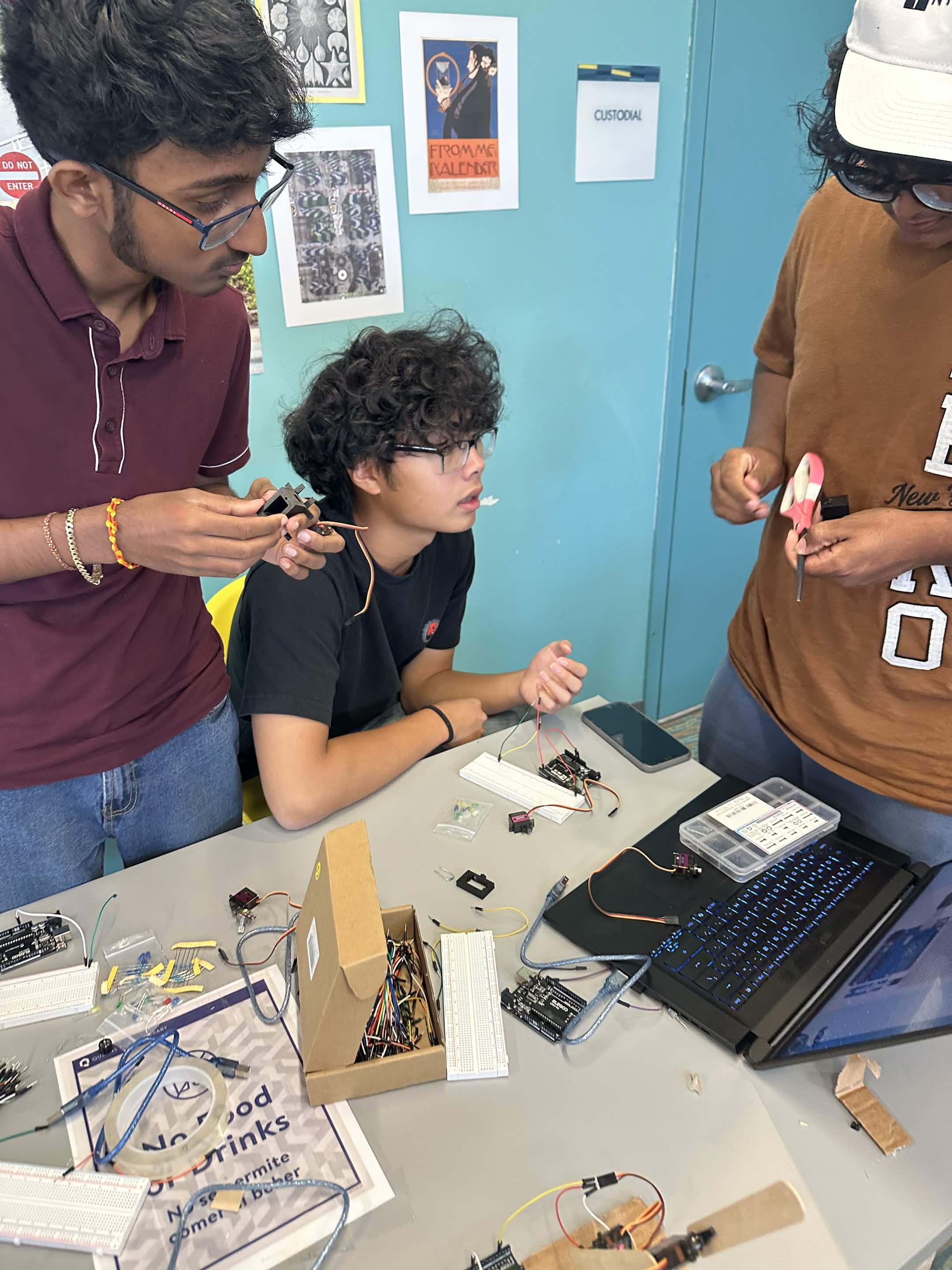 Mentors helping a student wire a servo motor