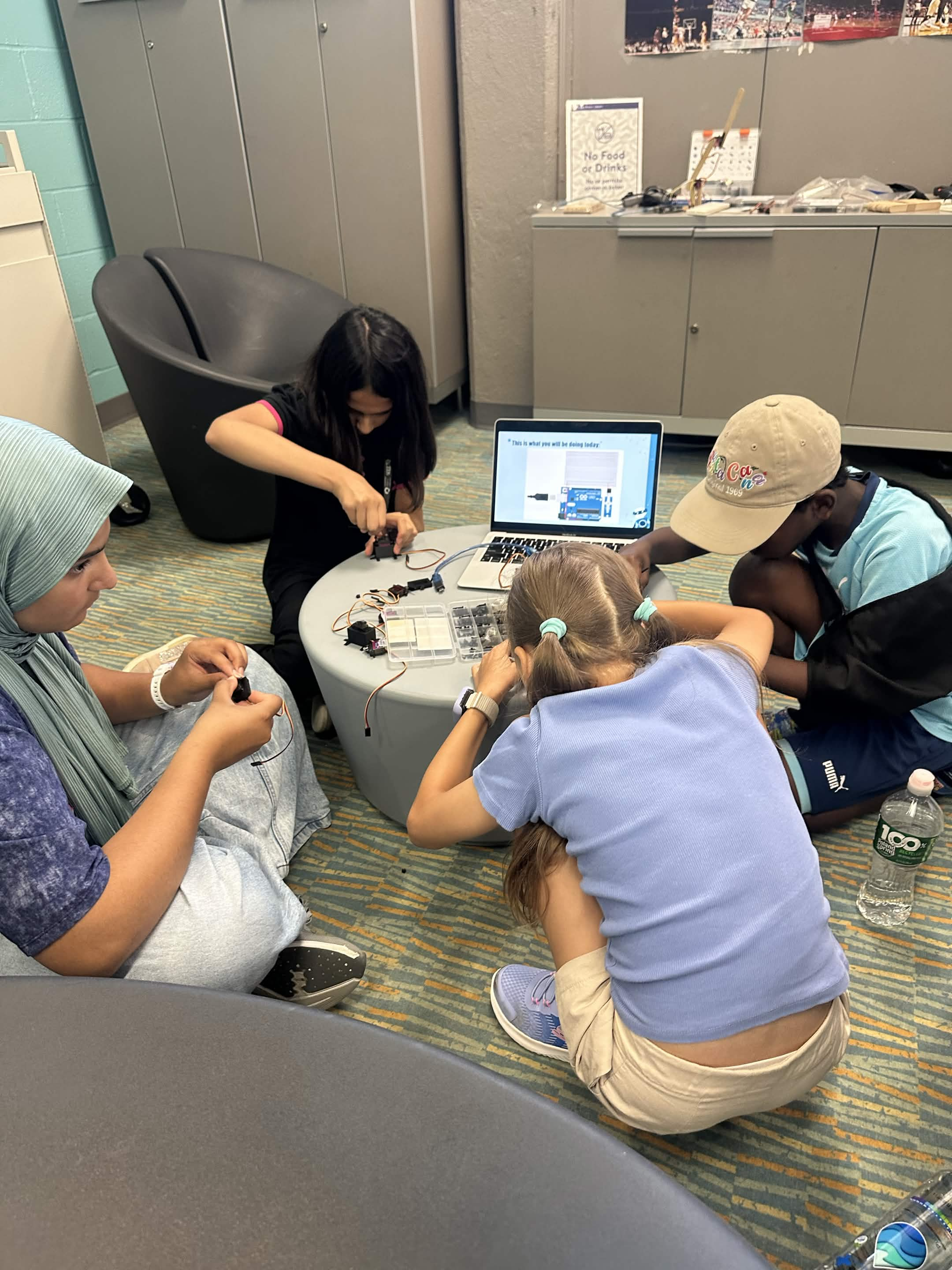 Group of students building circuits together on the floor